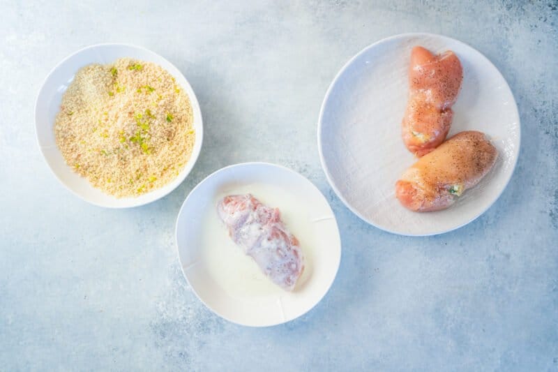 overhead view of wrapped chicken kiev being dipped in buttermilk.