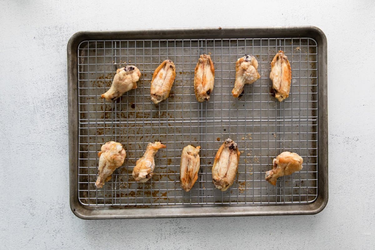 10 baked hot honey chicken wings on a wire rack set in a baking sheet.