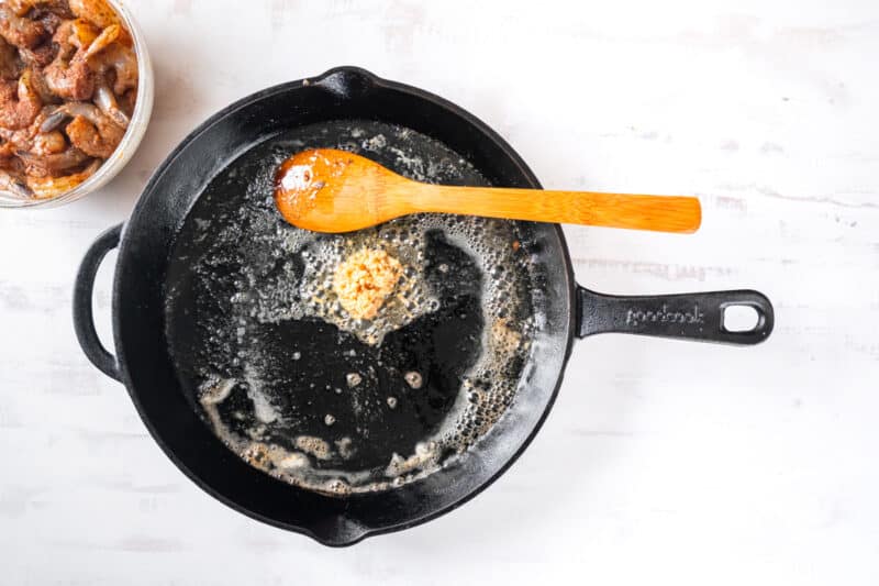 butter and oil sizzling in a skillet with a wooden spoon.