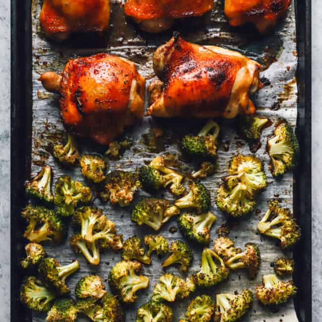 broccoli and 5 chicken thighs on a sheet pan.