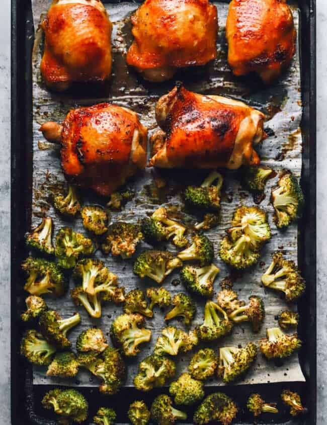 broccoli and 5 chicken thighs on a sheet pan.