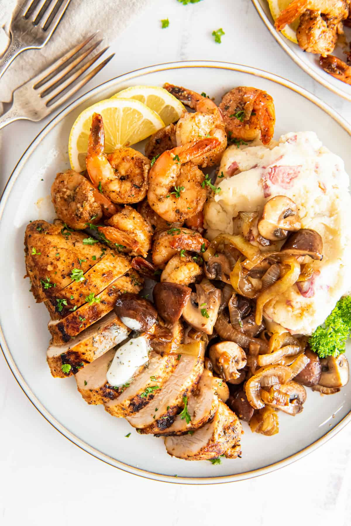 applebees bourbon street chicken and shrimp with mashed potatoes and mushrooms on a white plate.