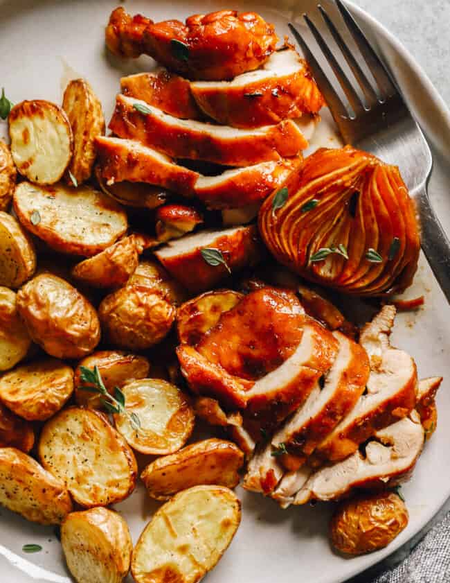 close up on a plate of sliced chicken and potatoes