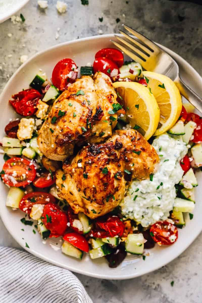 greek chicken thighs and greek salad on a plate