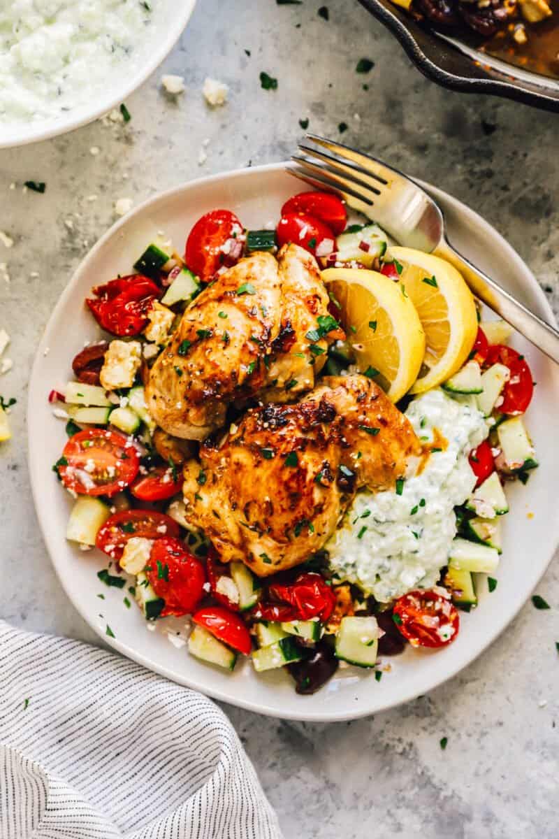 a plate piled up with salad and greek marinated chicken
