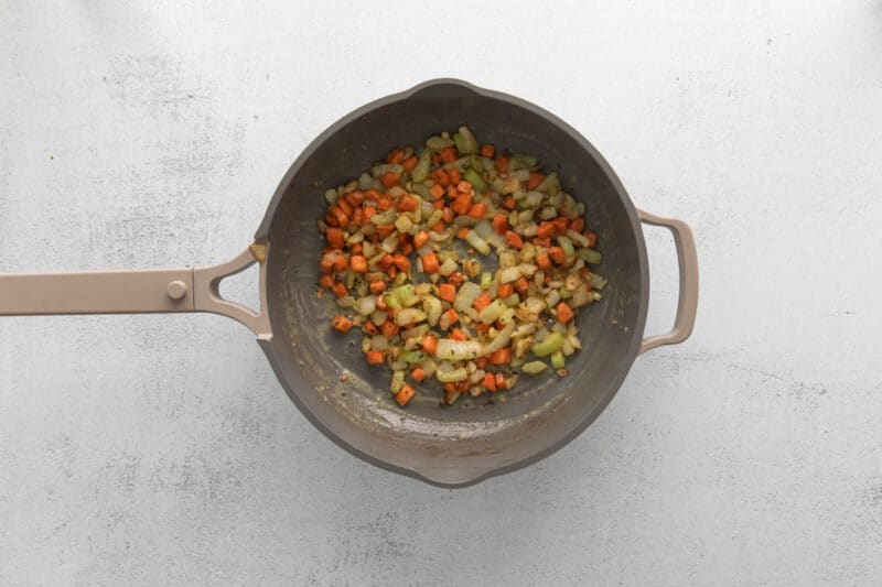 mirepoix with garlic and thyme in a frying pan.