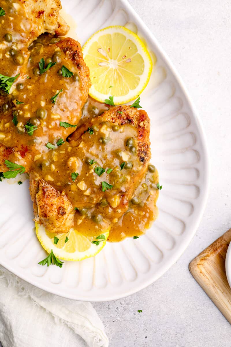 close up of instant pot chicken piccata on a white serving tray.