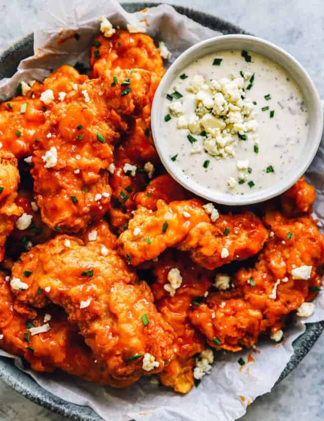 buffalo chicken tenders on a plate with ranch sauce.