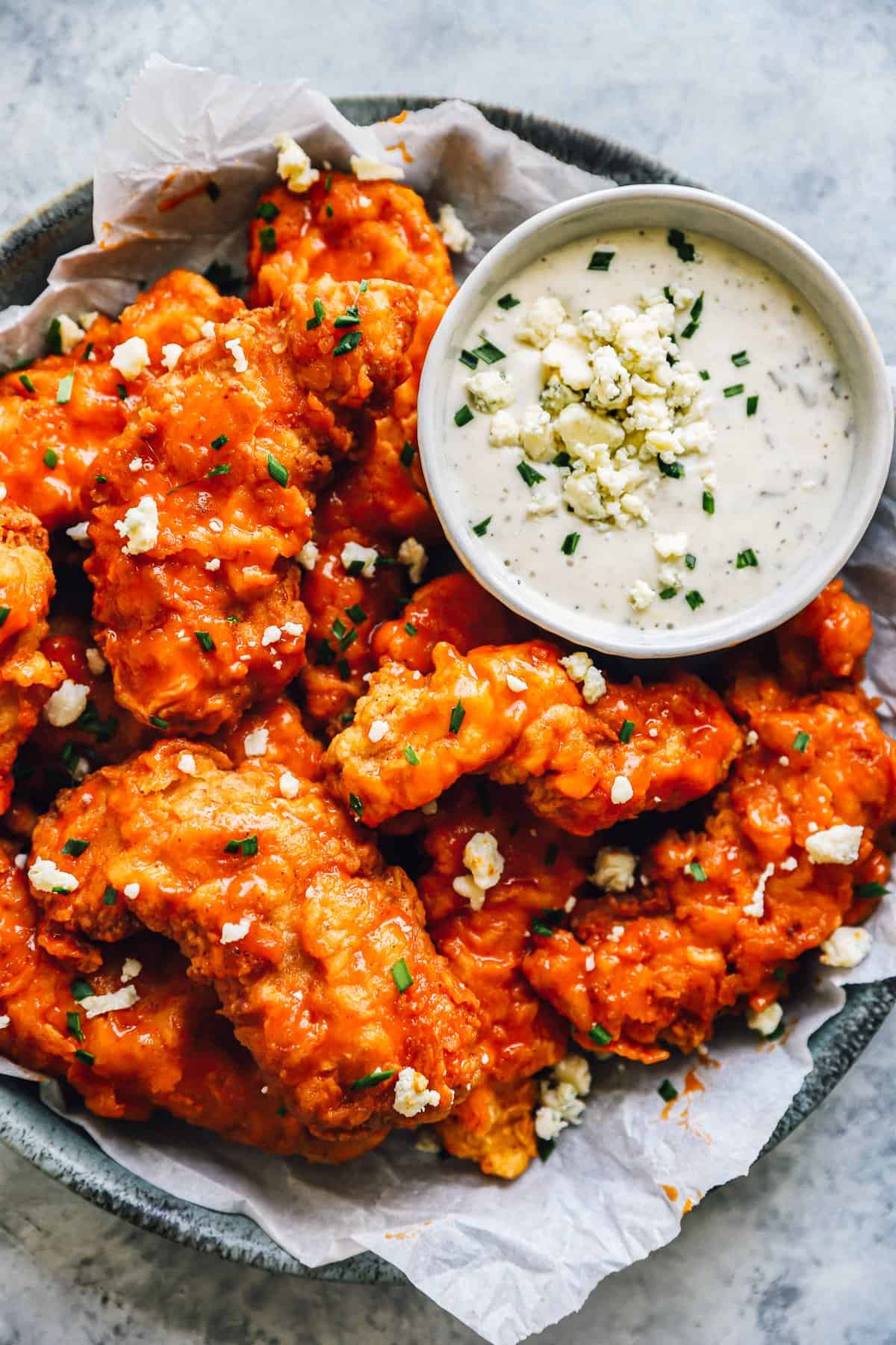 buffalo chicken tenders on a plate with ranch sauce.