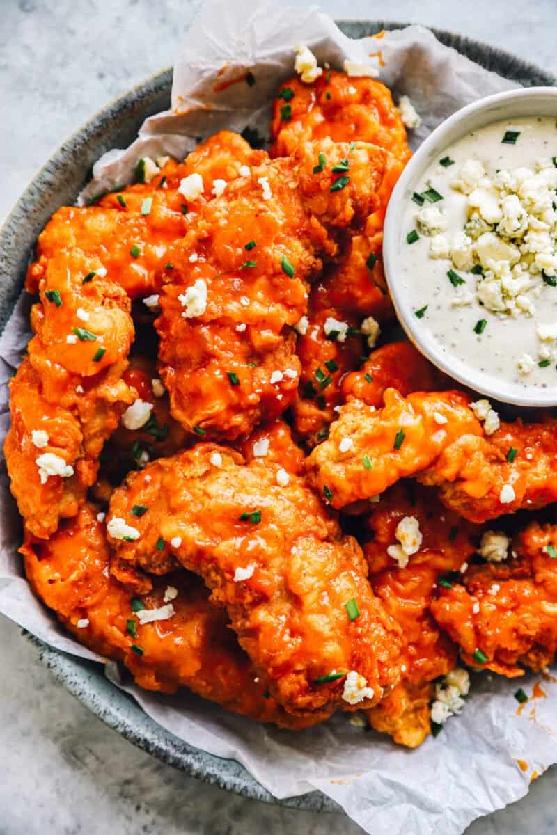 buffalo chicken tenders on a plate with ranch sauce.