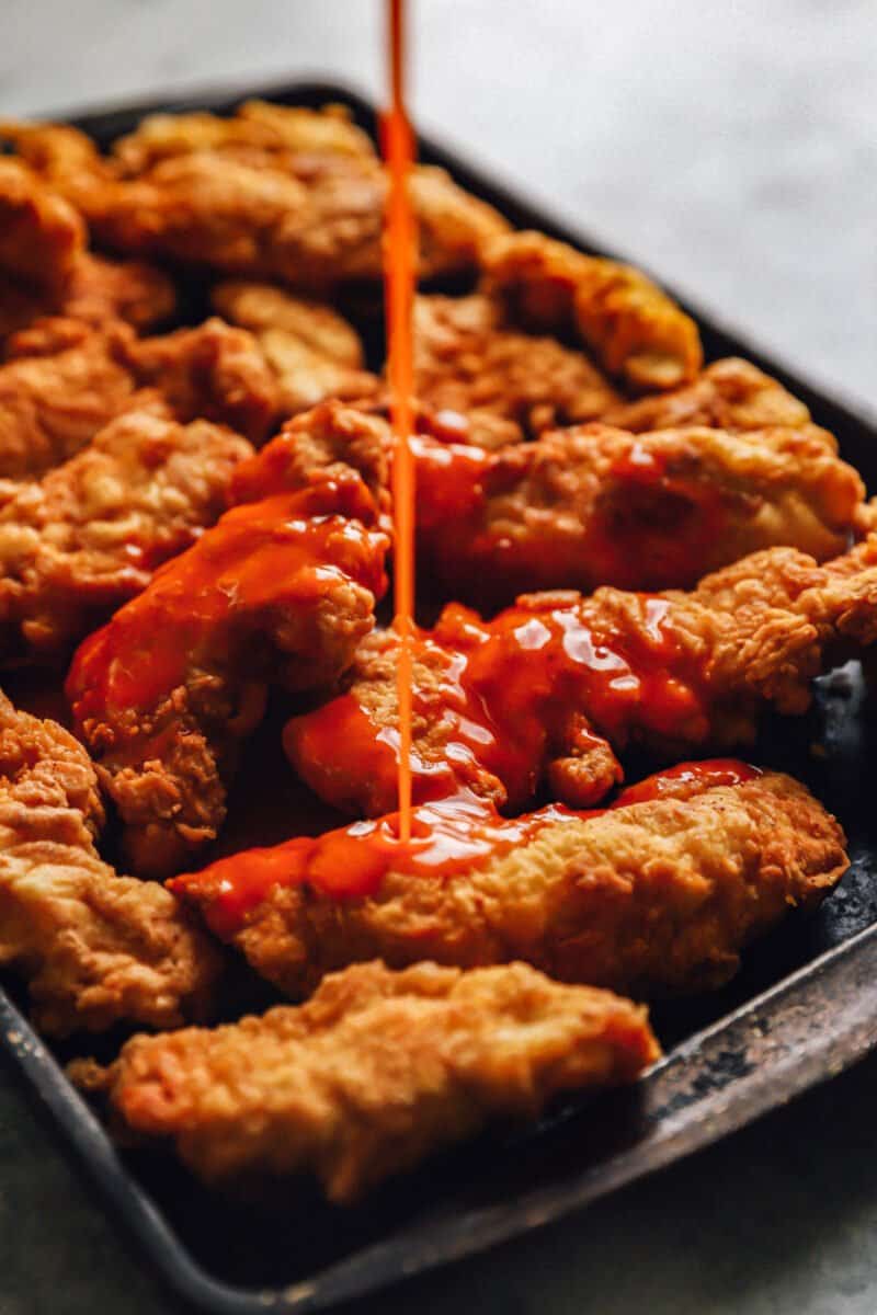 buffalo sauce poured over fried chicken tenders.