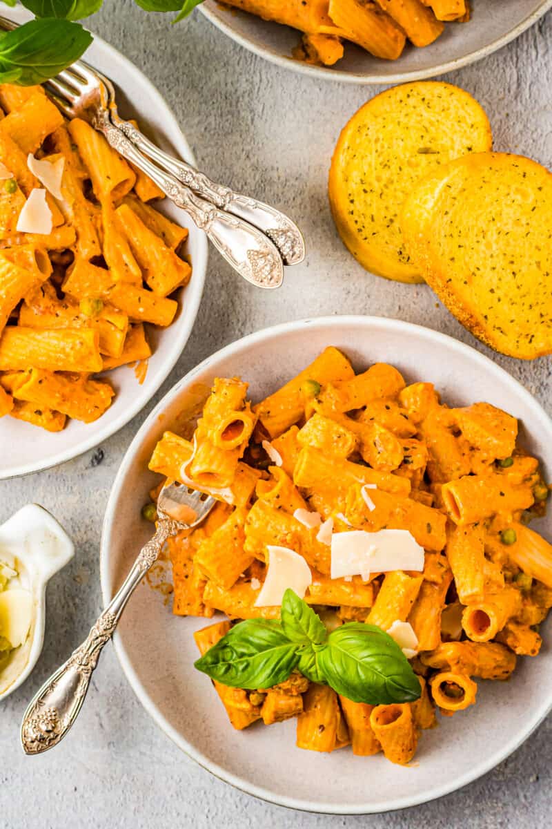 chicken rigatoni in white bowls with forks.