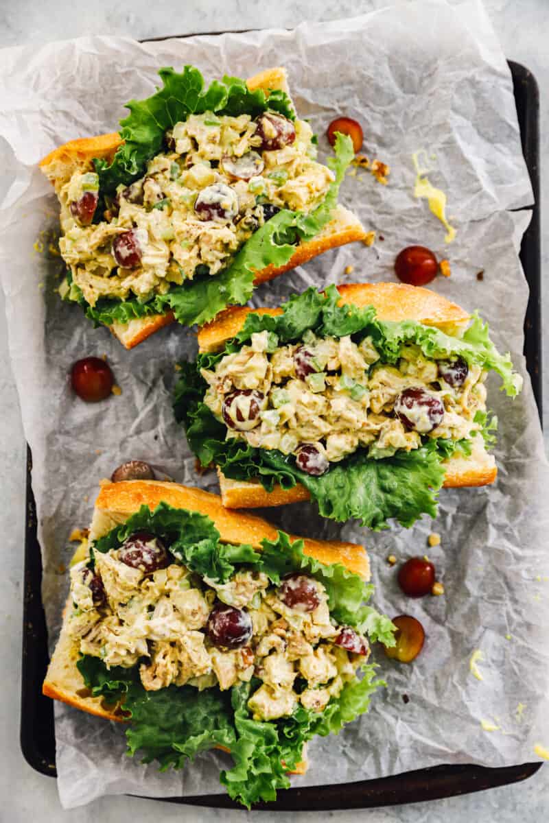 three honey mustard chicken salad sandwiches on a baking tray covered with parchment paper