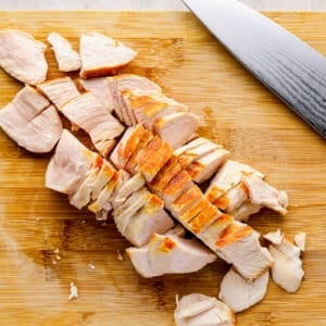 cutting up chicken breast on a cutting board