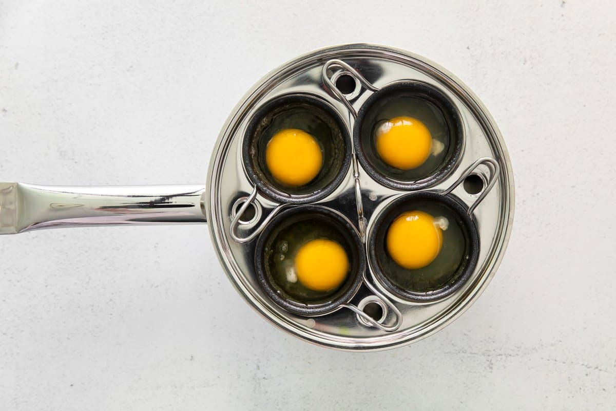 raw eggs in an egg poaching pan.
