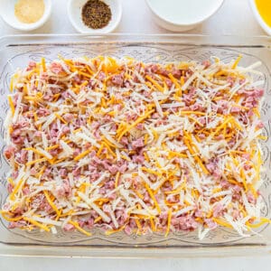ingredients for ham and cheese breakfast casserole in a casserole dish.