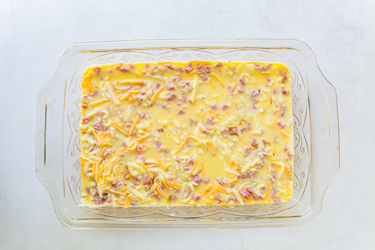 Eggs, ham, and cheese in a casserole dish.