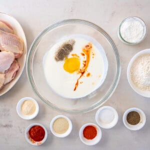 bowls of ingredients for hot honey fried chicken arranged on a table