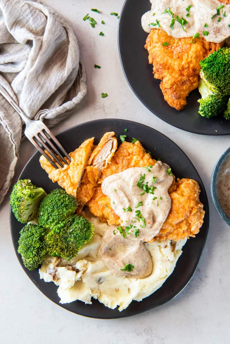 plate of country fried chicken, gravy, mashed potatoes, and broccoli