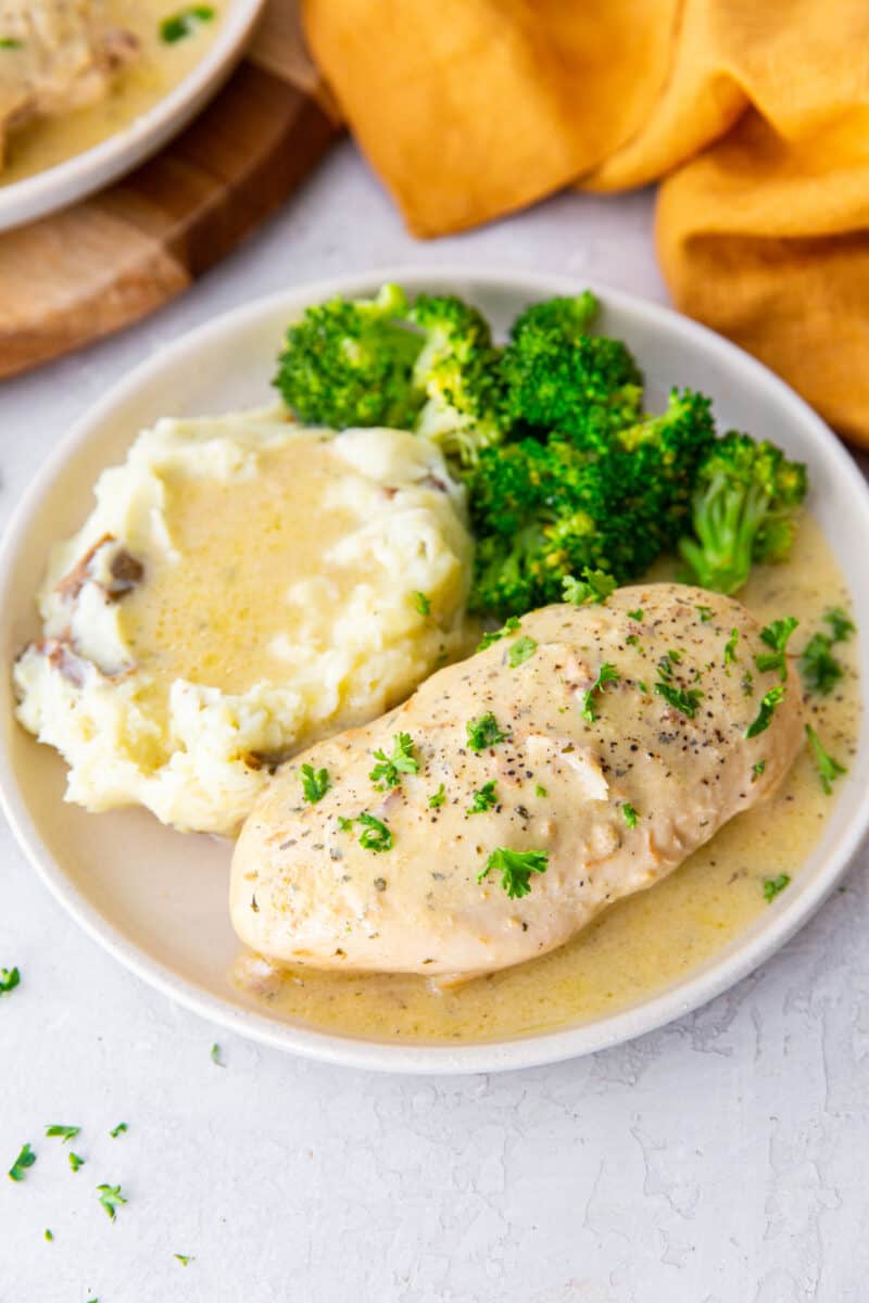 crockpot ranch chicken breast on a plate with mashed potatoes and broccoli