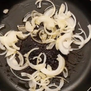 sautéeing onions in olive oil in a skillet.