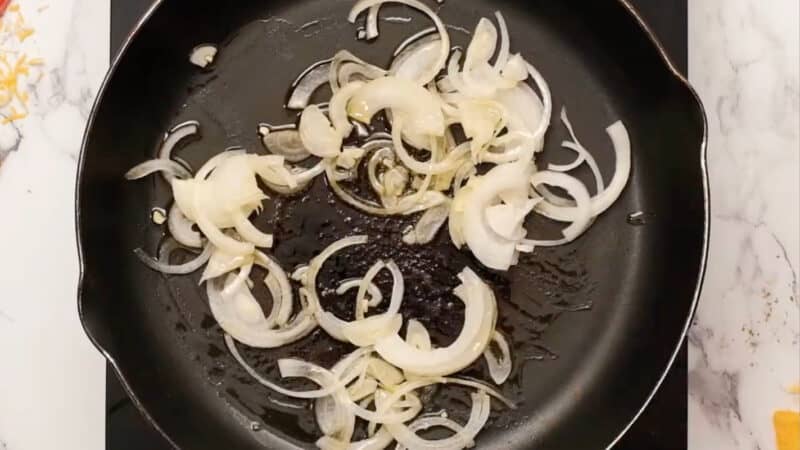 sautéeing onions in olive oil in a skillet.