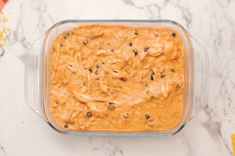 chicken enchilada dip in a glass baking pan.
