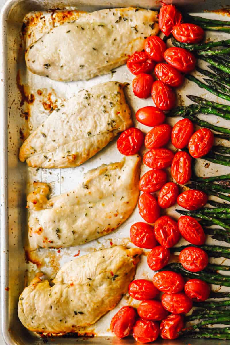 chicken and veggies arranged on a sheet pan