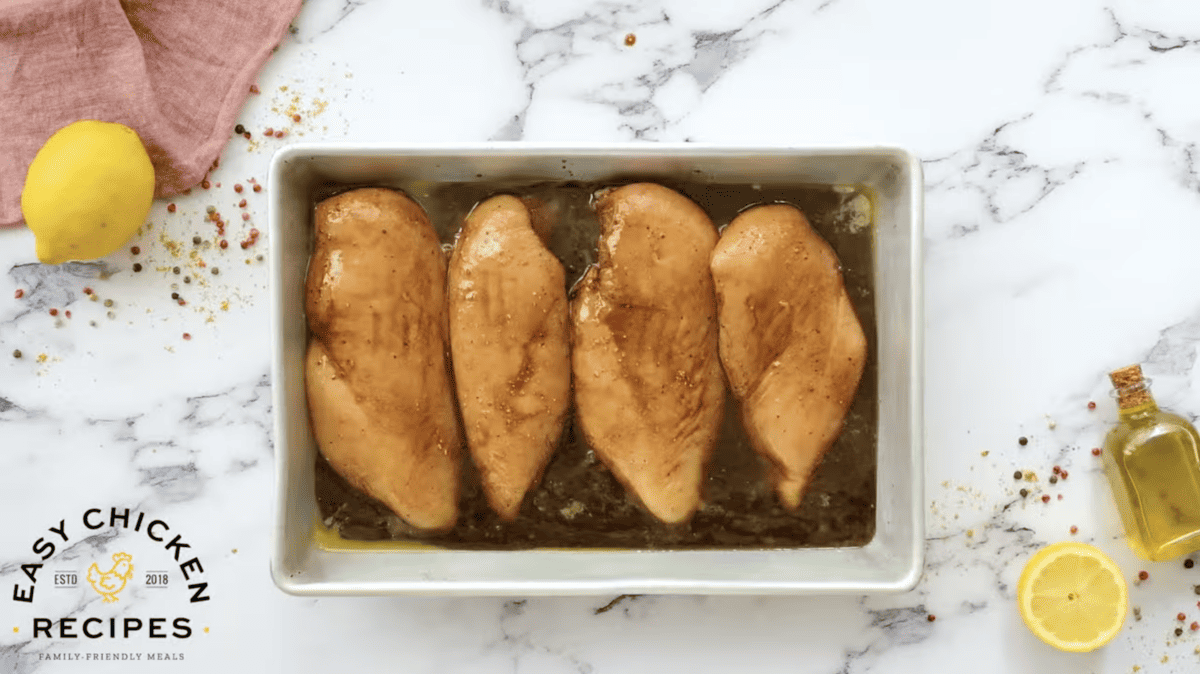 Baked chicken breasts in a pan with lemons and spices.