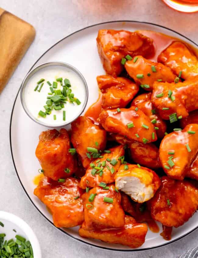 a plate of boneless wings with buffalo sauce