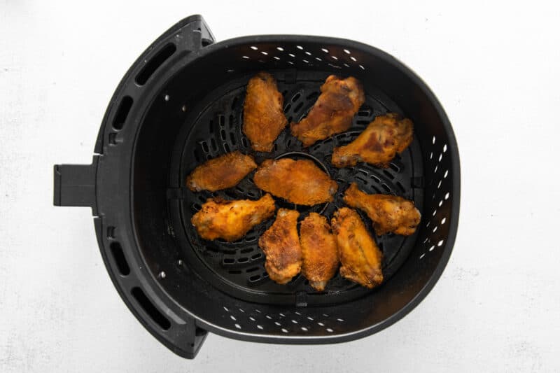 cooked chicken wings in an air fryer basket