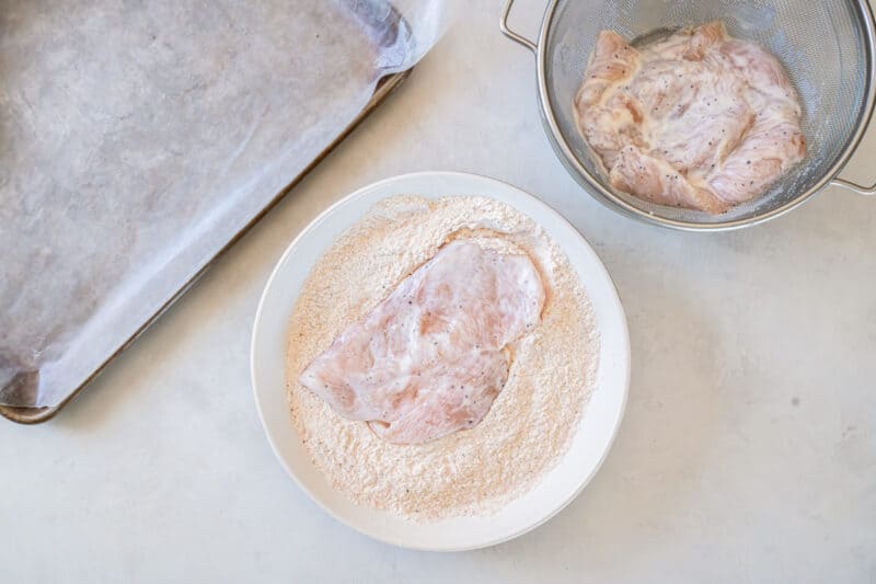 dredging chicken breasts in seasoned flour