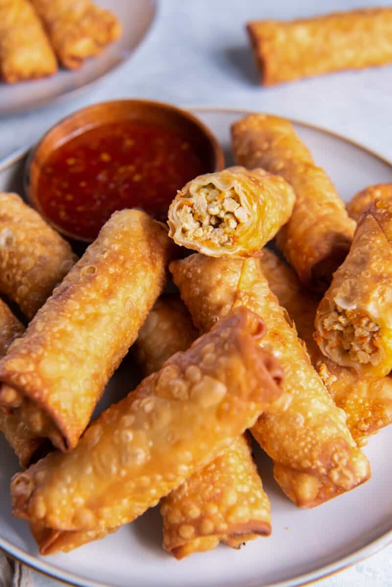 a plate of chicken egg rolls stacked up