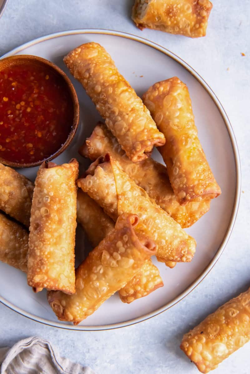 a plate of chicken egg rolls with dipping sauce