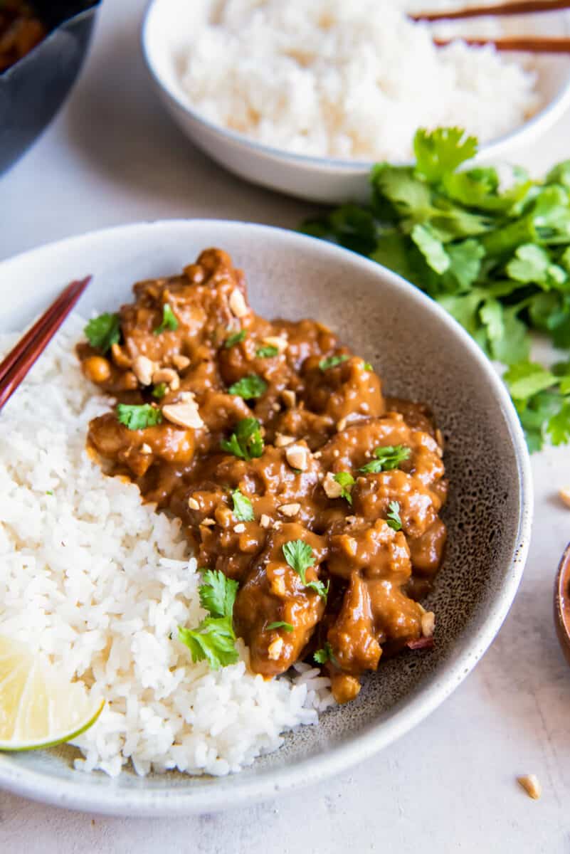 a bowl of chicken in peanut sauce, with white rice