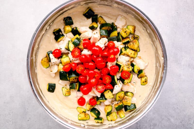 chopped tomatoes, zucchini, and chicken in a creamy sauce