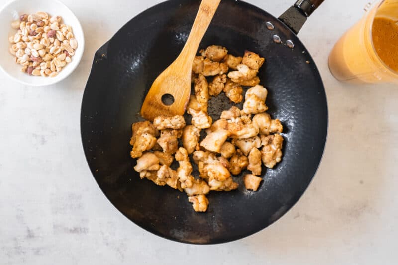 cooking pieces of chicken in a wok