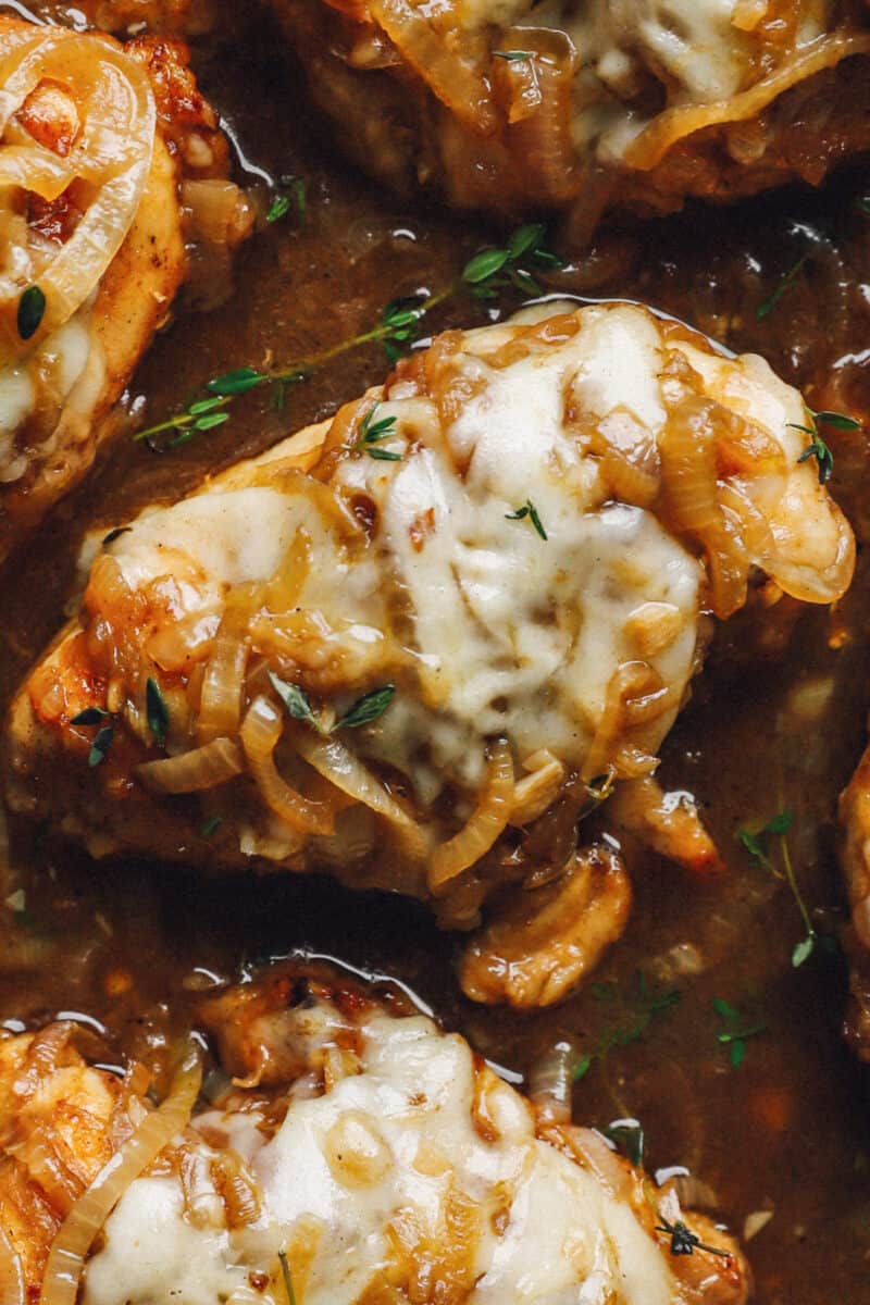 close up on a chicken cooked with caramelized onions and cheese