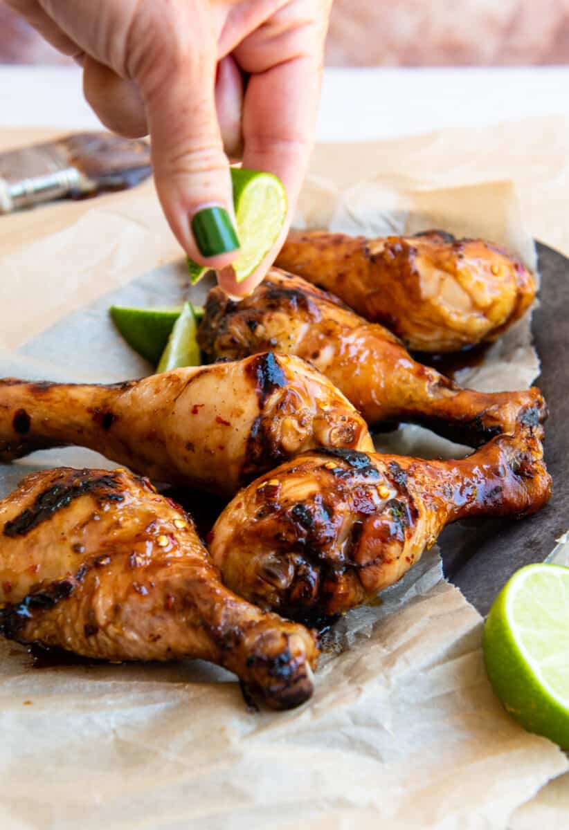 squeezing lime juice on grilled drumsticks