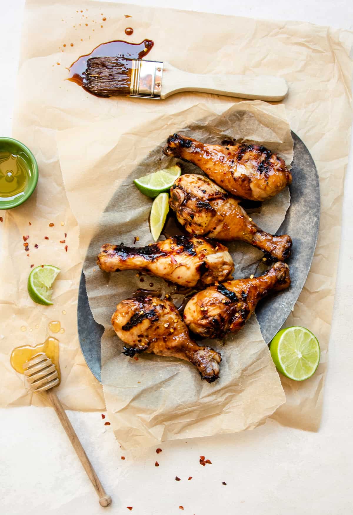 a plate of grilled chicken drumsticks covered in a honey lime sauce