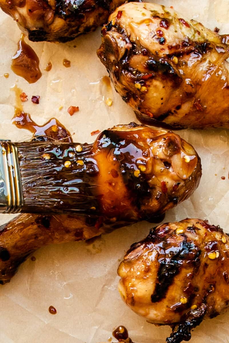 brushing chicken legs with honey lime sauce