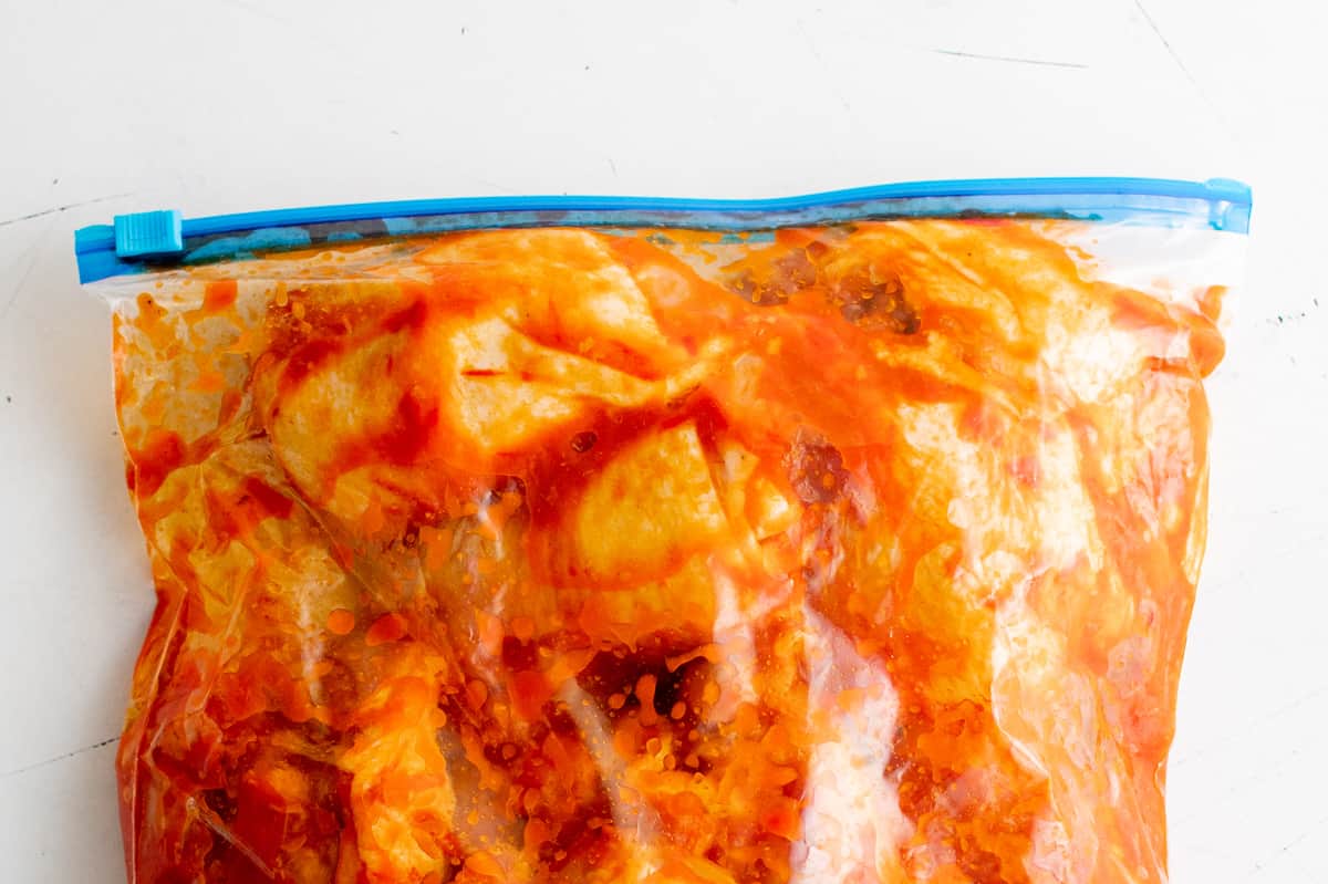 chicken thighs coated in harissa in a resealable bag