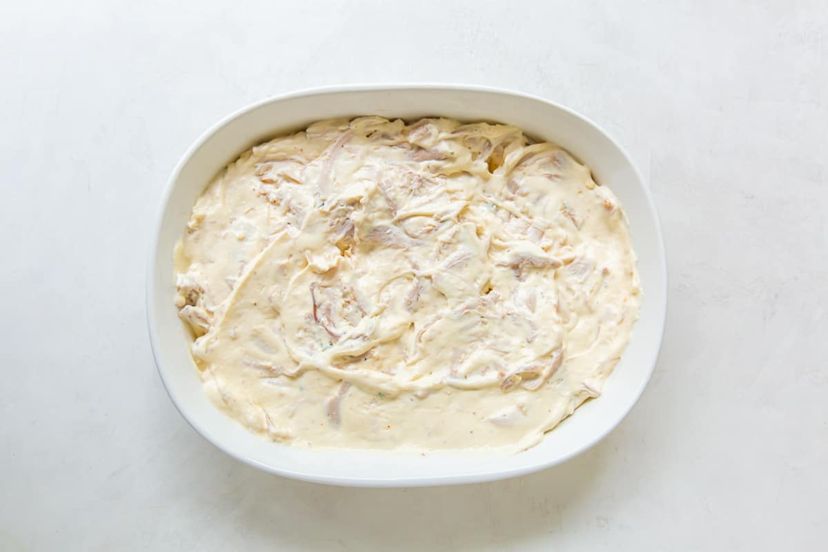 creamy chicken mixture layered into the casserole dish