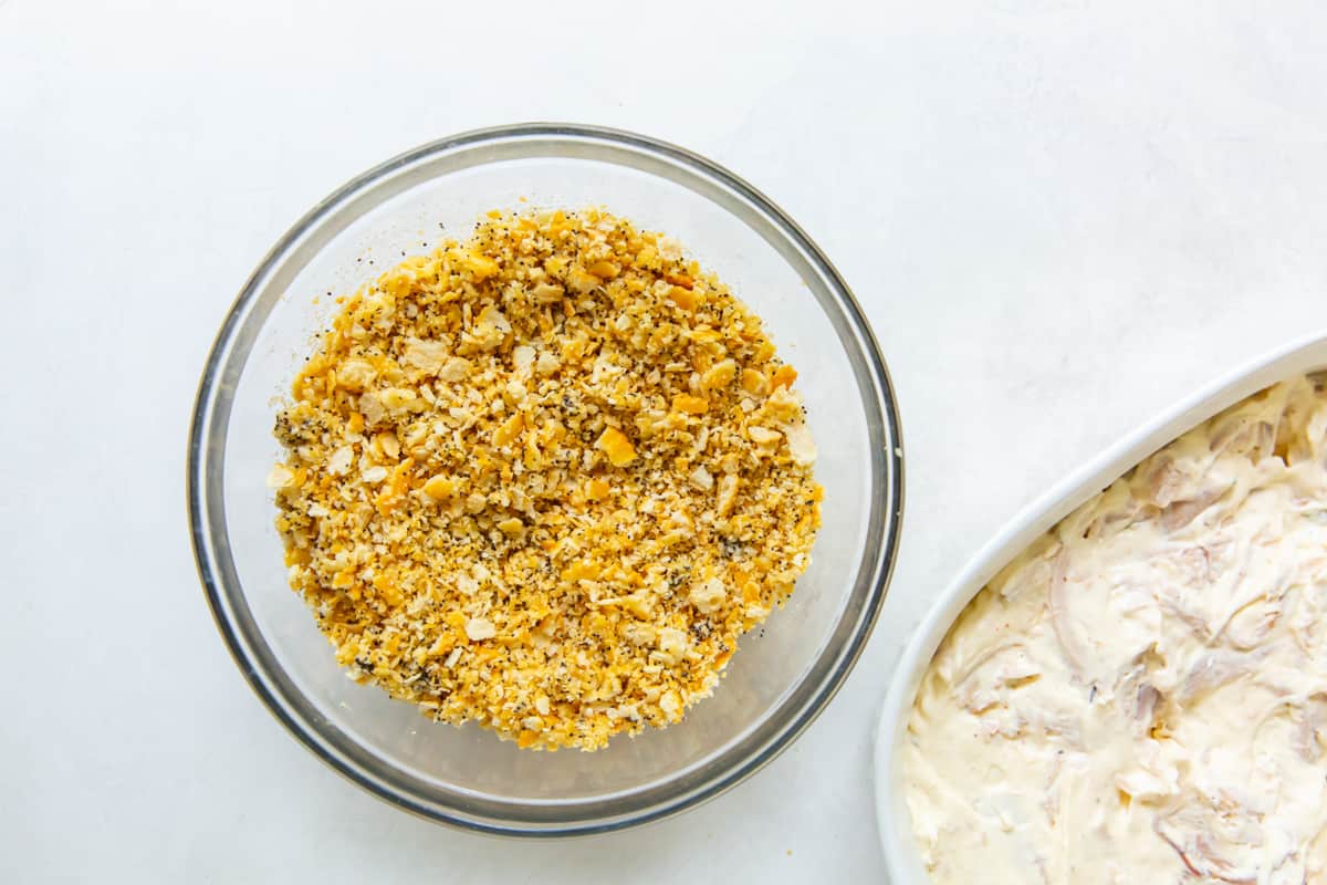 breadcrumb mixture in a mixing bowl, next to the casserole