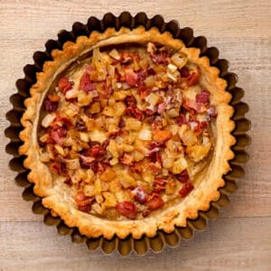 bacon bits and onions in the bottom of a quiche crust