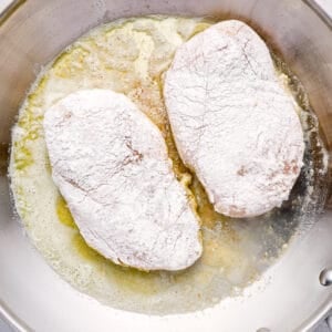 breaded chicken breasts frying in a pan