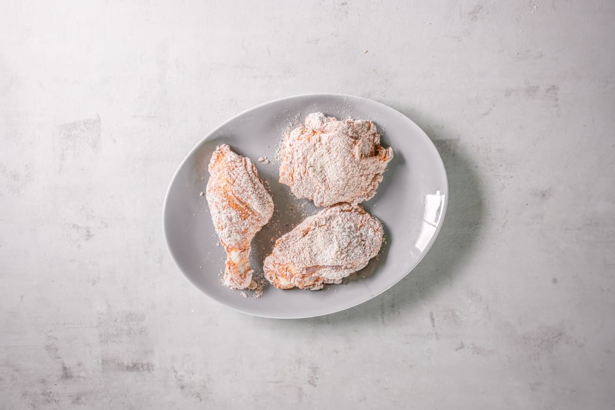 pieces of chicken coated in flour, before frying.