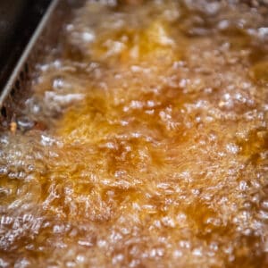 close up on chicken being deep fried in oil