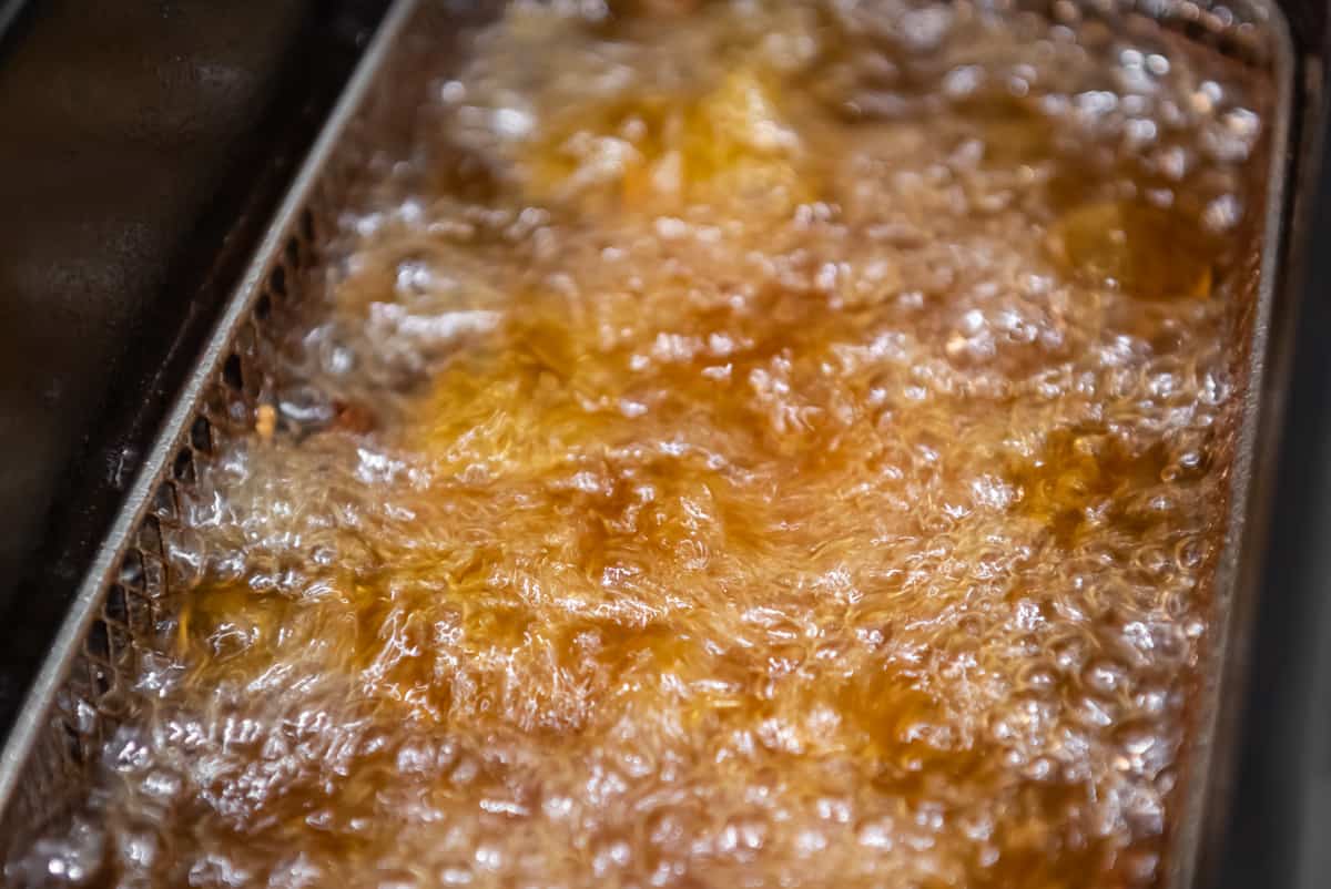 Close up on chicken being deep fried in oil.