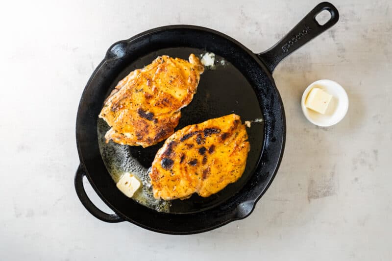 frying chicken in a pan with butter